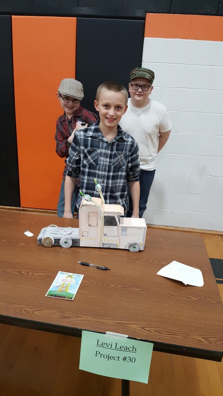 three children standing behind a display